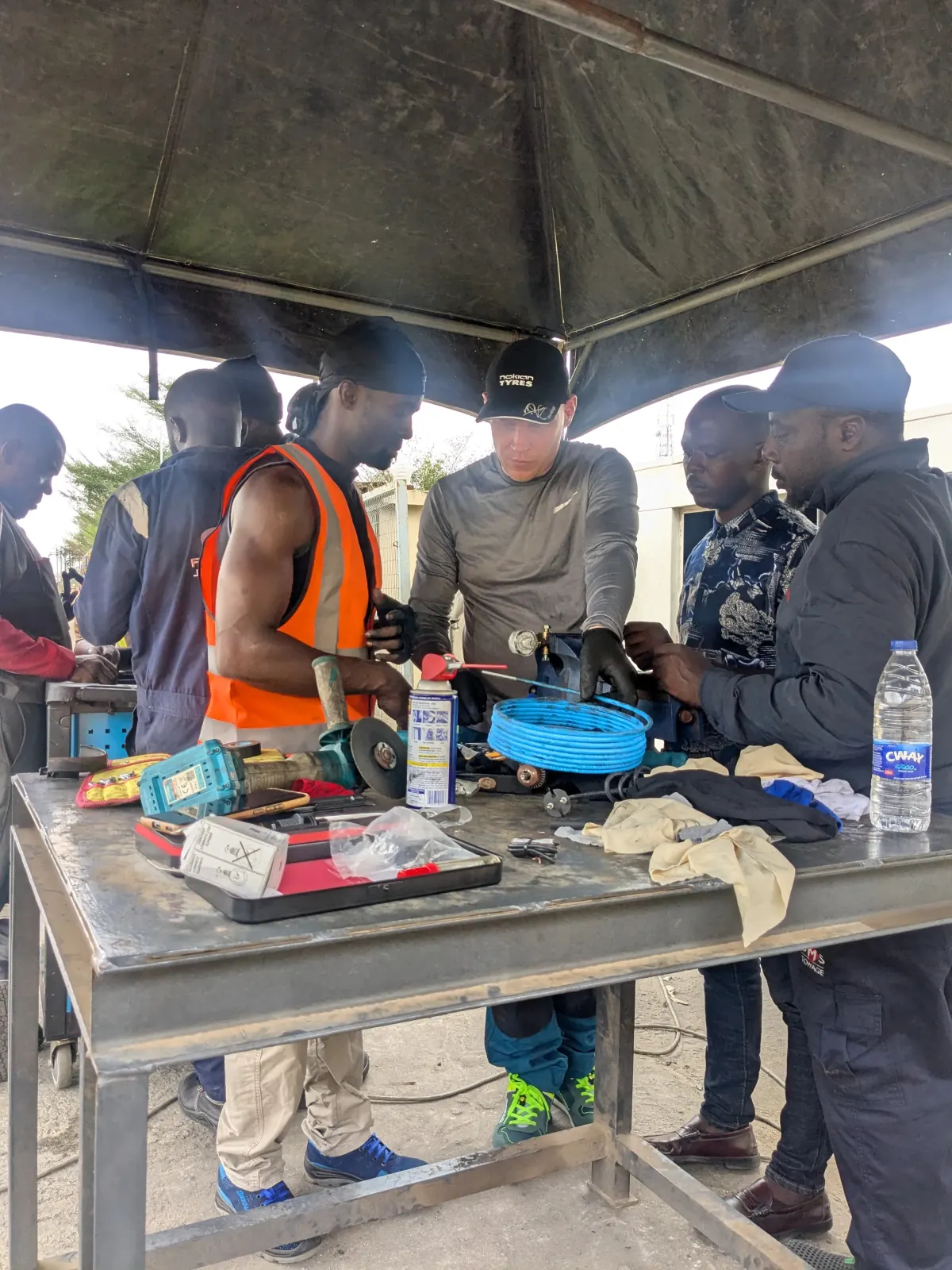 TEN conversion team reviewing components and tools around a workshop table